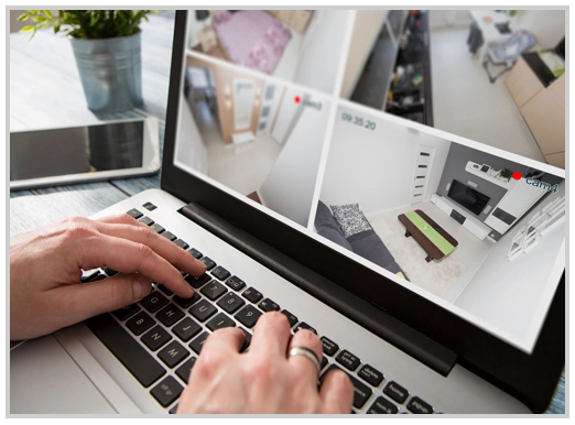 A person typing on a laptop with a photo of a room in the background.